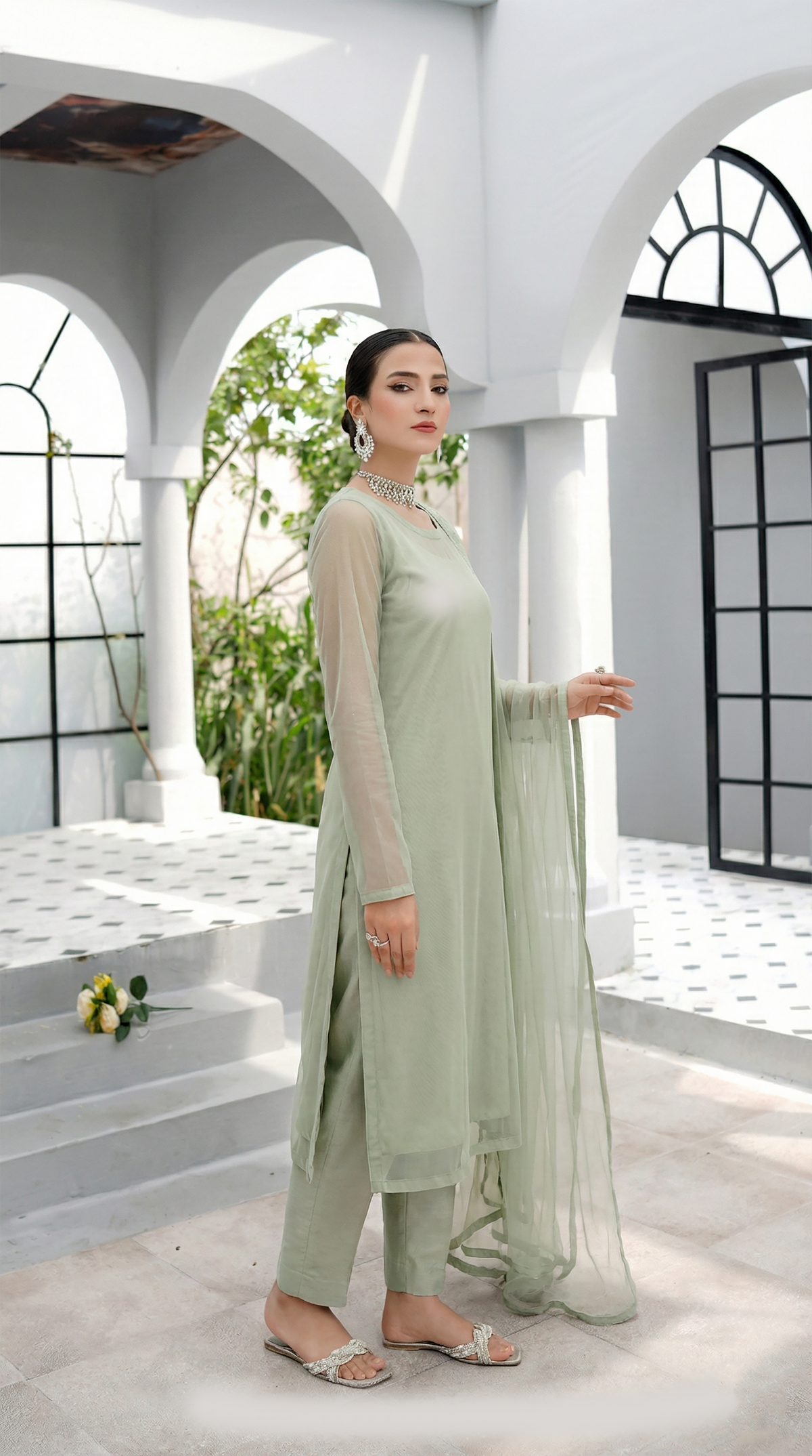 ROZAIB Sage Pista luxury Bareeze net long straight kurta stitched suit. This premium ready to wear stitched dress features a clean plain construction, ultra-fine 0.3mm micro-mesh net texture, and master-tailored vertical fall. A minimalist 3-piece stitched suit for women in a soft muted pistachio green tone, paired with raw silk cigarette trousers and an airy Bareeze net dupatta. Designed for a fresh, sophisticated festive look with zero embroidery and precision stitching.