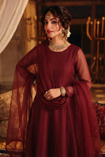 ROZAIB Deep Maroon luxury organza long frock stitched suit. This premium ready to wear stitched dress features a sophisticated light flare silhouette with 6-panel construction and sheer organza sleeves. A minimalist 3-piece stitched suit for women in a rich wine-red tone, paired with raw silk cigarette trousers and a lightweight Bareeze net dupatta. Designed for high-end festive evening wear with master-tailored pressed seams.