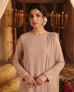 ROZAIB Nude Sand minimal festive stitched suit in premium flowy chiffon fabric. This luxury ready to wear stitched dress features a straight relaxed flow fit with ultra-fine micro chiffon grain and master-tailored vertical lines. A 3-piece stitched suit for women designed for effortless elegance, paired with raw silk cigarette trousers and a lightweight Bareeze net dupatta. Perfect for a sophisticated minimalist look in any season.