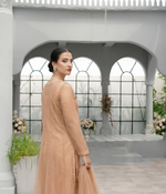 ROZAIB Champagne Peach luxury Bareeze net minimal kalidaar stitched suit. This premium ready to wear stitched dress features a 12-kali graceful flow fit, ultra-fine 0.3mm micro-mesh texture, and master-tailored vertical kali joints. A minimalist 3-piece stitched suit for women in a warm champagne-peach tone, paired with raw silk cigarette trousers and an airy Bareeze net dupatta. Designed for a traditional yet modern festive look with zero embroidery.