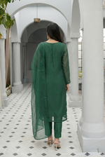 ROZAIB Forest Green luxury organza stitched suit for women. This premium ready to wear stitched dress features a unique suspended-yoke architecture with a floating vertical structure and master-tailored seamless finish. A minimalist 3-piece stitched suit in a rich forest green earthy tone, paired with raw silk relaxed trousers and a matching airy organza dupatta. Designed for a calm, authoritative executive look with zero embroidery.