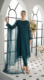 ROZAIB Teal Blue luxury solid organza stitched suit for women. This premium ready to wear stitched dress features a seamless front panel with architectural structured tailoring and a clean matte finish. A minimalist 3-piece stitched suit in a rich teal blue jewel tone, paired with raw silk straight trousers and a matching solid organza dupatta. Designed for a powerful, uninterrupted executive look with zero embroidery.