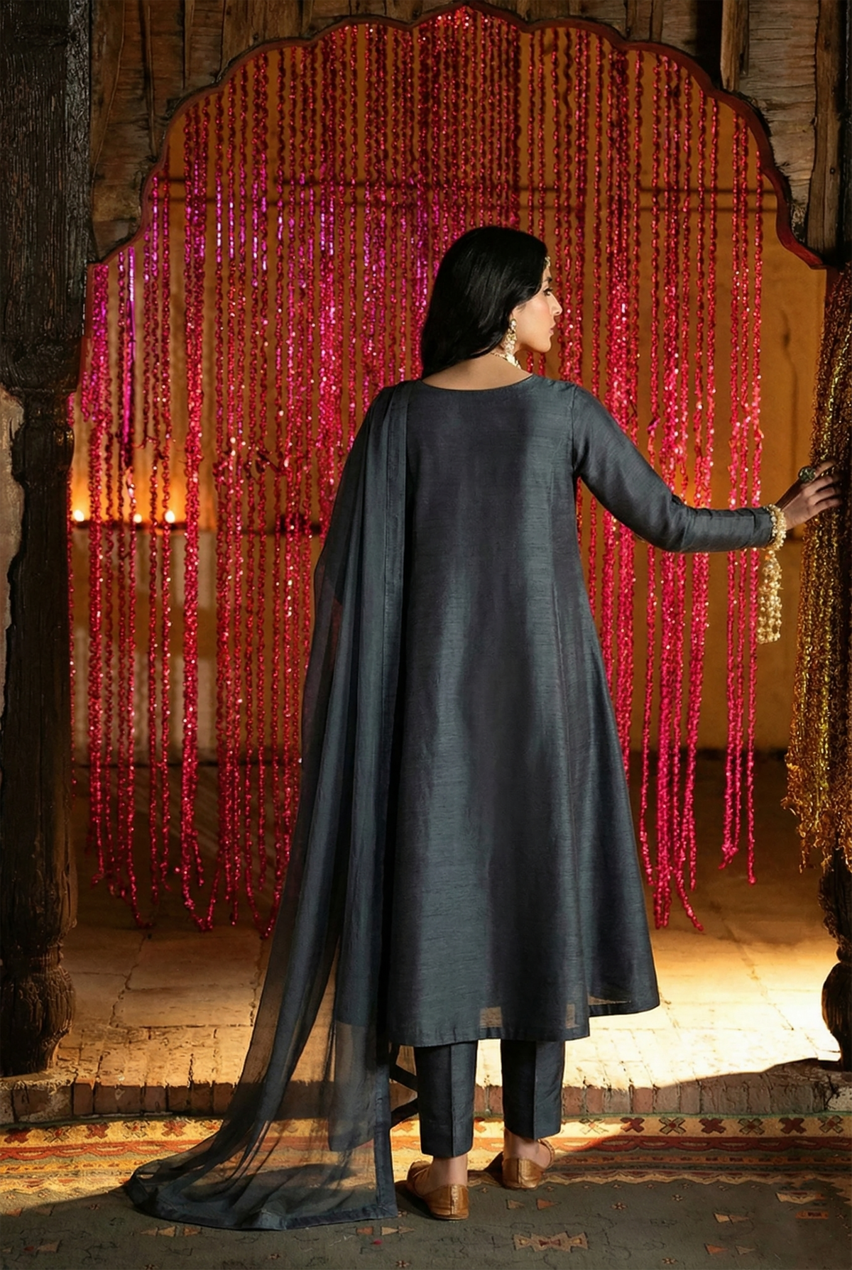 ROZAIB Deep Charcoal executive A-line stitched suit in premium raw silk fabric. This luxury ready to wear stitched dress features a sophisticated structured silhouette with authentic raw silk slub texture. A minimalist 3-piece stitched suit for women, designed for an authoritative and professional look, paired with straight cigarette pants and a matching fluid chiffon dupatta. Ideal for office wear and formal festive gatherings.
