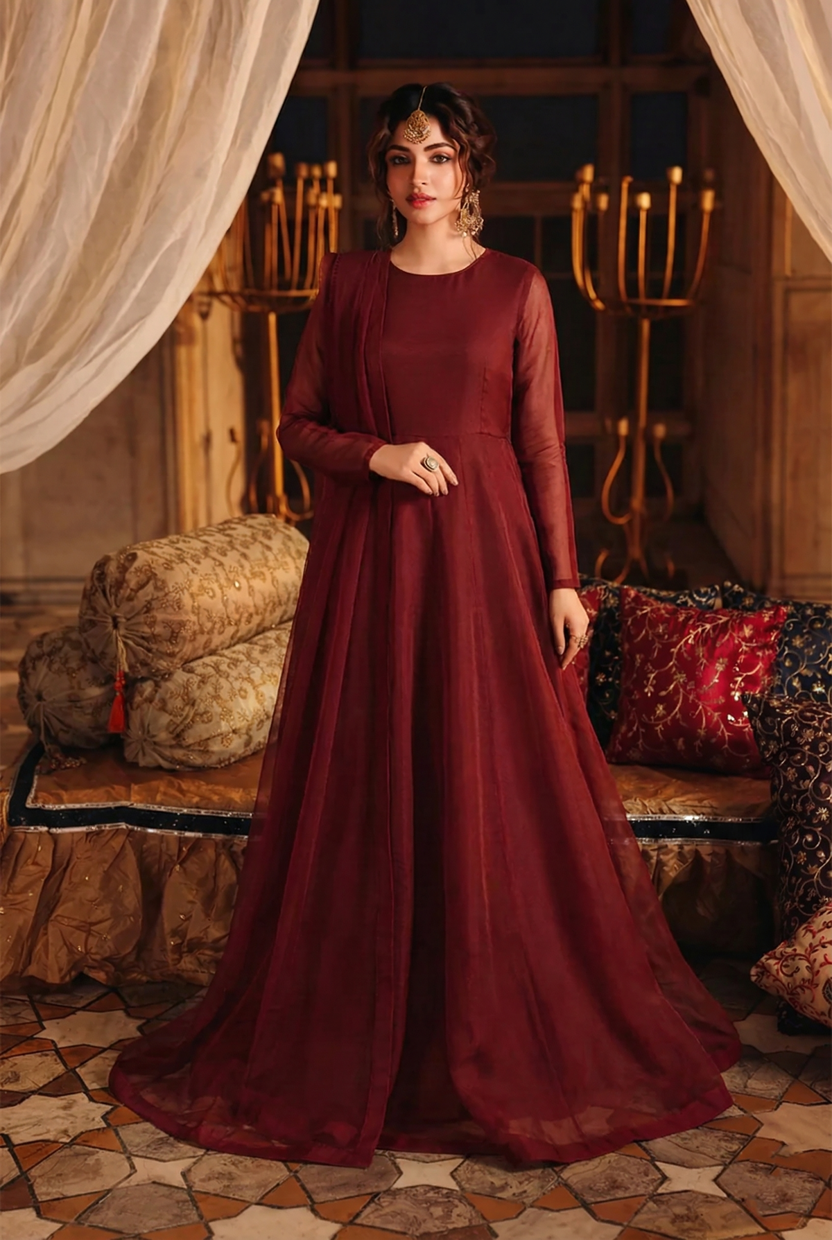 ROZAIB Deep Maroon luxury organza long frock stitched suit. This premium ready to wear stitched dress features a sophisticated light flare silhouette with 6-panel construction and sheer organza sleeves. A minimalist 3-piece stitched suit for women in a rich wine-red tone, paired with raw silk cigarette trousers and a lightweight Bareeze net dupatta. Designed for high-end festive evening wear with master-tailored pressed seams.