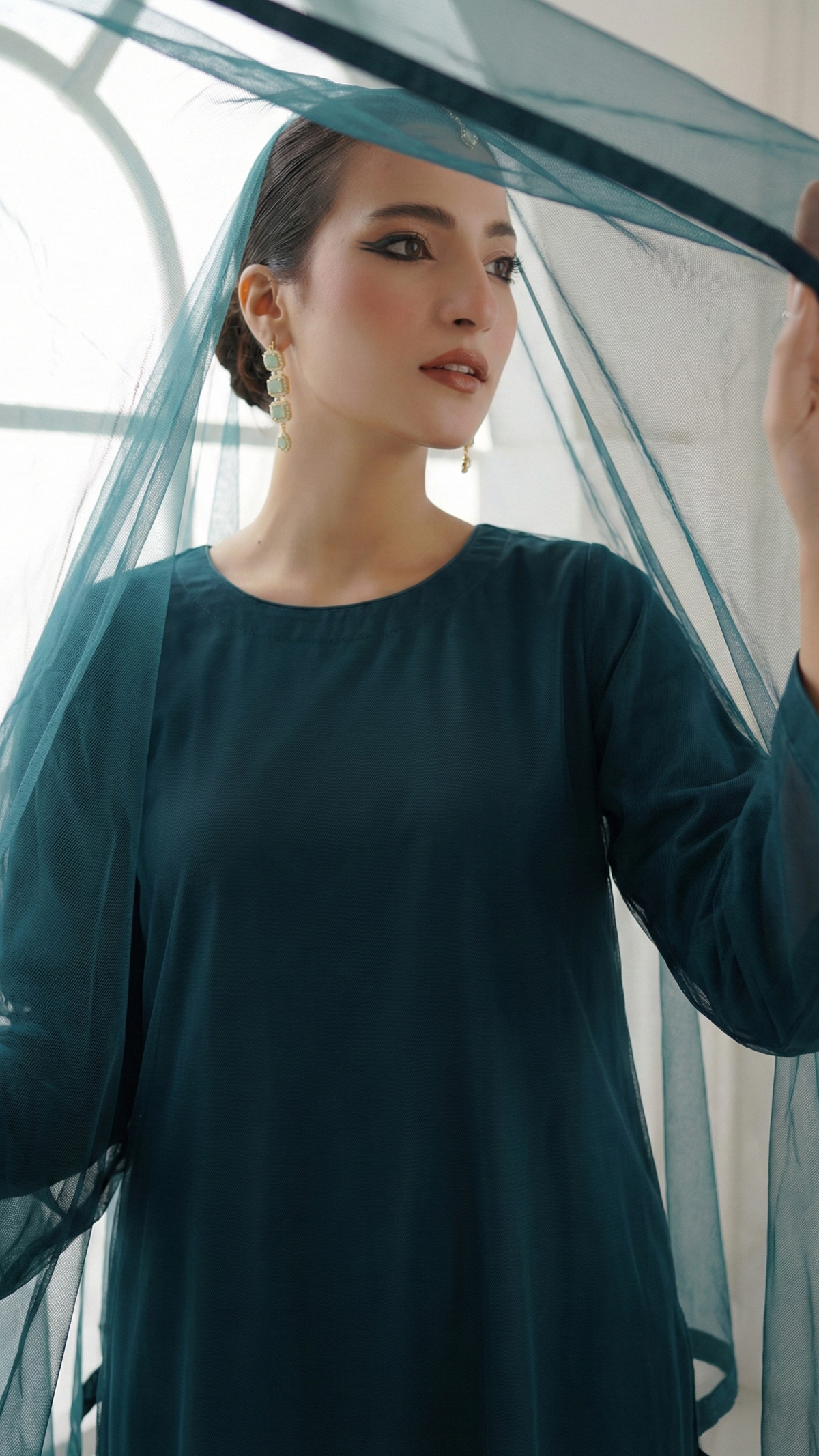 ROZAIB Teal Blue luxury solid organza stitched suit for women. This premium ready to wear stitched dress features a seamless front panel with architectural structured tailoring and a clean matte finish. A minimalist 3-piece stitched suit in a rich teal blue jewel tone, paired with raw silk straight trousers and a matching solid organza dupatta. Designed for a powerful, uninterrupted executive look with zero embroidery.