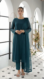 ROZAIB Teal Blue luxury solid organza stitched suit for women. This premium ready to wear stitched dress features a seamless front panel with architectural structured tailoring and a clean matte finish. A minimalist 3-piece stitched suit in a rich teal blue jewel tone, paired with raw silk straight trousers and a matching solid organza dupatta. Designed for a powerful, uninterrupted executive look with zero embroidery.