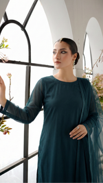 ROZAIB Teal Blue luxury solid organza stitched suit for women. This premium ready to wear stitched dress features a seamless front panel with architectural structured tailoring and a clean matte finish. A minimalist 3-piece stitched suit in a rich teal blue jewel tone, paired with raw silk straight trousers and a matching solid organza dupatta. Designed for a powerful, uninterrupted executive look with zero embroidery.