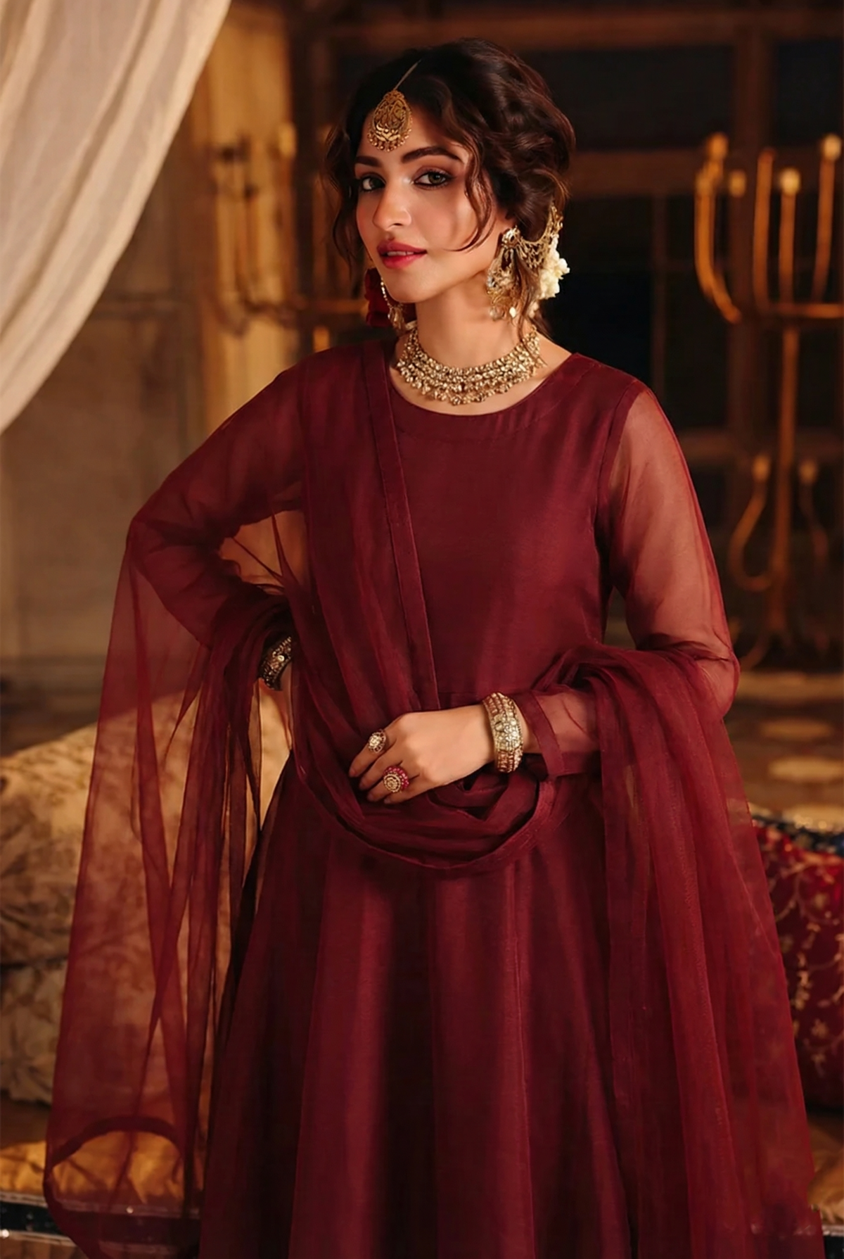 ROZAIB Deep Maroon luxury organza long frock stitched suit. This premium ready to wear stitched dress features a sophisticated light flare silhouette with 6-panel construction and sheer organza sleeves. A minimalist 3-piece stitched suit for women in a rich wine-red tone, paired with raw silk cigarette trousers and a lightweight Bareeze net dupatta. Designed for high-end festive evening wear with master-tailored pressed seams.