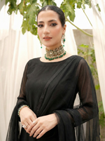 ROZAIB Coal Black luxury Bareeze net high slit stitched suit. This premium ready to wear stitched dress features a straight long kurta with 16-inch reinforced side slits, ultra-fine 0.3mm micro-mesh texture, and a clean boat neckline. A minimalist 3-piece stitched suit for women in a deep neutral coal black tone, paired with raw silk cigarette trousers and an airy Bareeze net dupatta. Designed for a sharp, sophisticated festive look with zero embroidery.