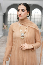 ROZAIB Champagne Peach luxury Bareeze net minimal kalidaar stitched suit. This premium ready to wear stitched dress features a 12-kali graceful flow fit, ultra-fine 0.3mm micro-mesh texture, and master-tailored vertical kali joints. A minimalist 3-piece stitched suit for women in a warm champagne-peach tone, paired with raw silk cigarette trousers and an airy Bareeze net dupatta. Designed for a traditional yet modern festive look with zero embroidery.