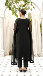 ROZAIB Coal Black luxury Bareeze net high slit stitched suit. This premium ready to wear stitched dress features a straight long kurta with 16-inch reinforced side slits, ultra-fine 0.3mm micro-mesh texture, and a clean boat neckline. A minimalist 3-piece stitched suit for women in a deep neutral coal black tone, paired with raw silk cigarette trousers and an airy Bareeze net dupatta. Designed for a sharp, sophisticated festive look with zero embroidery.