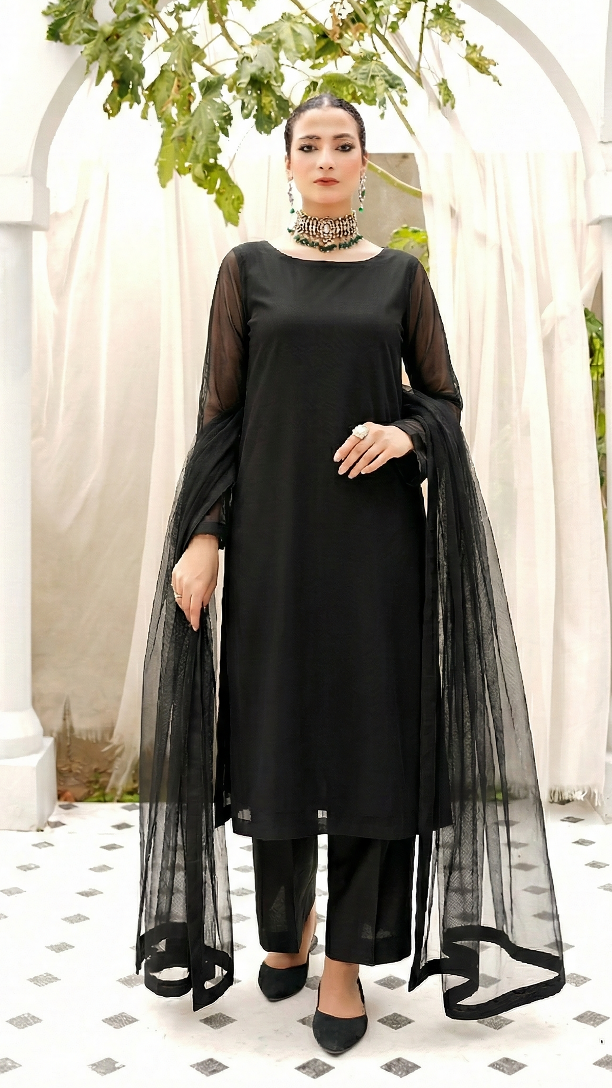ROZAIB Coal Black luxury Bareeze net high slit stitched suit. This premium ready to wear stitched dress features a straight long kurta with 16-inch reinforced side slits, ultra-fine 0.3mm micro-mesh texture, and a clean boat neckline. A minimalist 3-piece stitched suit for women in a deep neutral coal black tone, paired with raw silk cigarette trousers and an airy Bareeze net dupatta. Designed for a sharp, sophisticated festive look with zero embroidery.