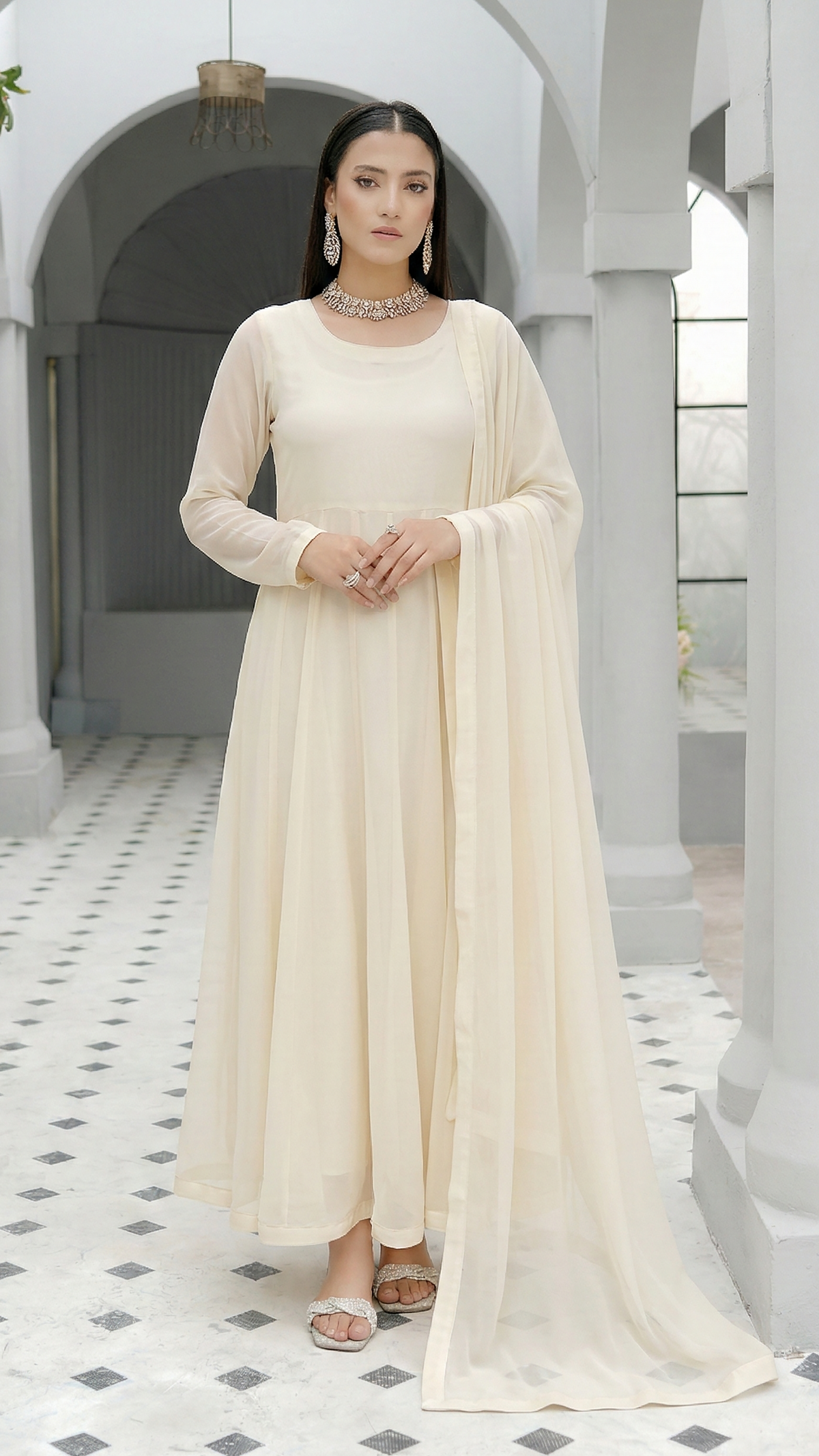 ROZAIB Ivory Cream luxury chiffon soft kalidaar stitched suit. This premium ready to wear stitched dress features a 12-panel radial construction, ultra-fine dry matte chiffon texture, and a graceful soft circular flare. A minimalist 3-piece stitched suit for women in a luminous warm ivory tone, designed for effortless festive elegance with zero embroidery and master-tailored invisible stitching.