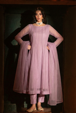 ROZAIB Mauve Lilac minimal kalidaar stitched suit in premium Bareeze net. This luxury ready to wear stitched dress features an 8-panel structured flow fit with ultra-fine micro-mesh texture and invisible seam junctions. A 3-piece stitched suit for women in a soft romantic pastel tone, paired with raw silk cigarette pants and an airy Bareeze net dupatta. Designed for a sophisticated festive look with zero embroidery.