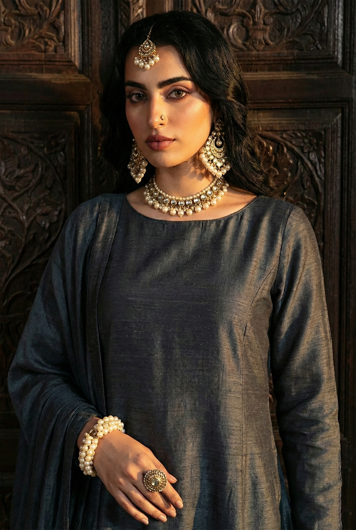 ROZAIB Deep Charcoal executive A-line stitched suit in premium raw silk fabric. This luxury ready to wear stitched dress features a sophisticated structured silhouette with authentic raw silk slub texture. A minimalist 3-piece stitched suit for women, designed for an authoritative and professional look, paired with straight cigarette pants and a matching fluid chiffon dupatta. Ideal for office wear and formal festive gatherings.
