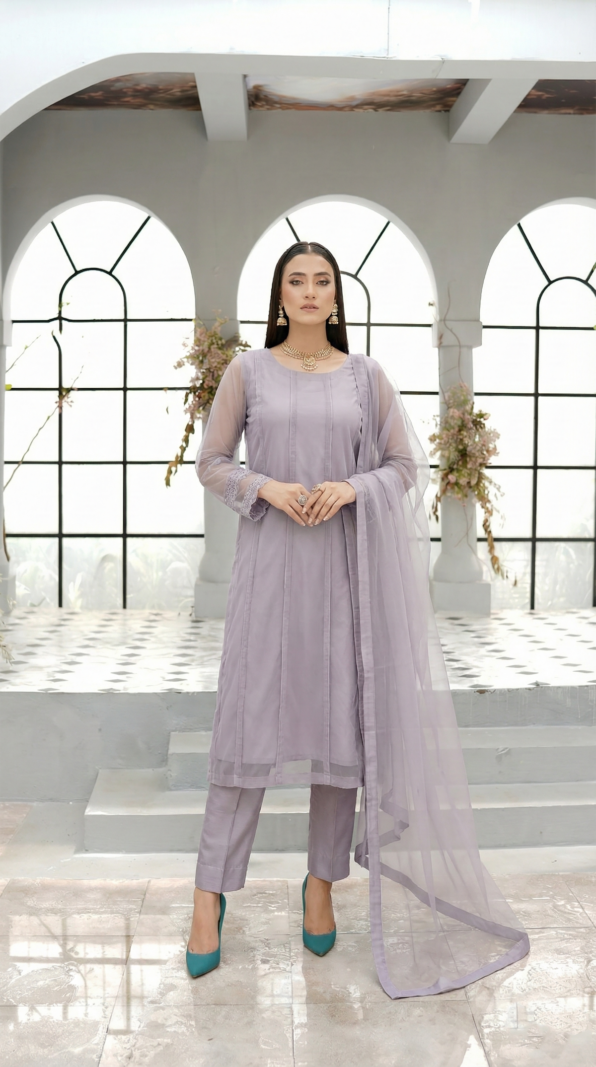ROZAIB Lavender Grey luxury Bareeze net soft panel stitched suit. This premium ready to wear stitched dress features a 6-panel long frock silhouette with ultra-fine 0.3mm micro-mesh texture and master-tailored vertical panel lines. A minimalist 3-piece stitched suit for women in a cool muted lilac-grey tone, paired with raw silk cigarette trousers and an airy Bareeze net dupatta. Designed for a calm, sophisticated festive look with zero embroidery and precision stitching.
